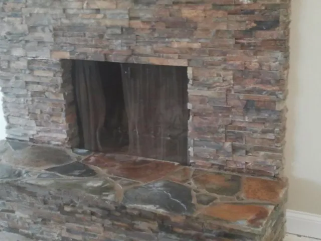 Stacked-stone fireplace surround with a flagstone hearth.