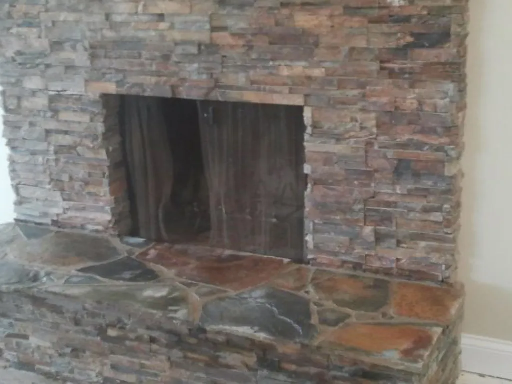Stacked natural stone fireplace surround with a flagstone hearth, built floor to ceiling in a San Diego home.
