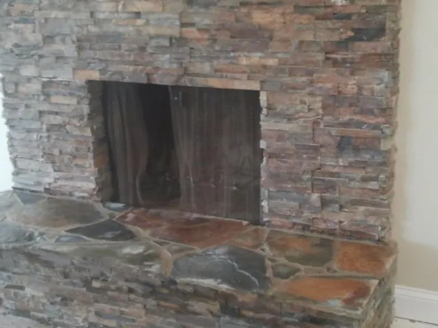 A stacked-stone fireplace surround with a raised flagstone hearth.