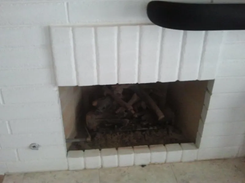 Brick fireplace refinished in white with a rebuilt hearth course.
