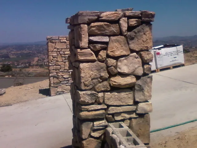 Close-up of a fieldstone pillar with a flat stone cap.