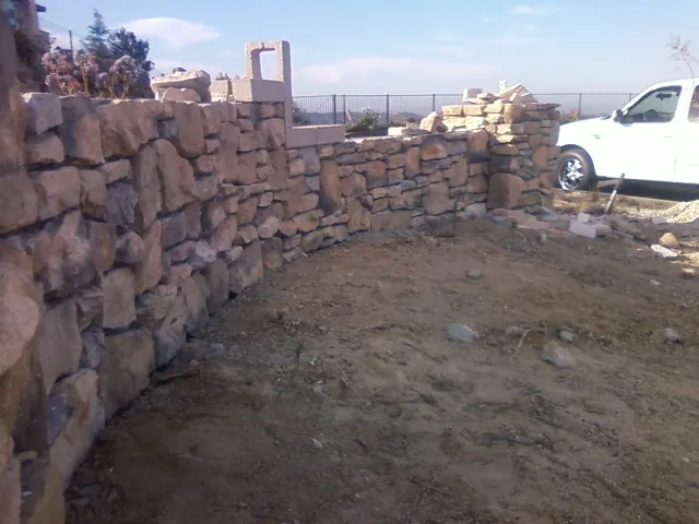 Natural stone veneer going onto the curved wall, with stone staged on site.